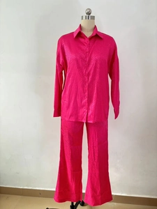 Détail de chemise et pantalon large en satin rose fuchsia avec texture à motif léopard