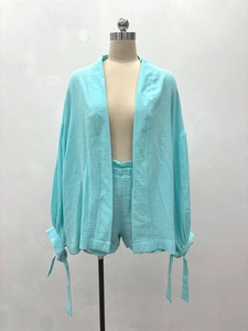 Détail de la texture gaufrée bleu clair et poignets noués sur cet ensemble ample femme