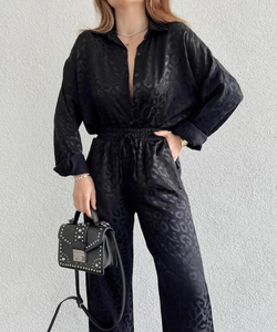 Detail of black leopard jacquard satin texture on long sleeve shirt and trousers set