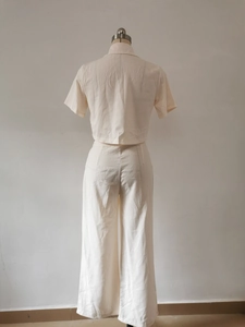 Rear view of women's two-piece linen set featuring short-sleeve shirt and wide-leg trousers