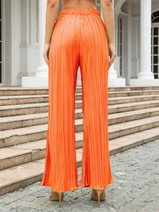 Detail view of bright orange pleated wide-leg trousers with high elastic waist and back view
