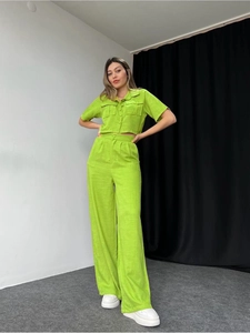 Detail of lime green short sleeve button shirt and high waist wide leg pants set
