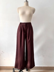Detailed front view of high-waisted wide leg trousers with pleated waist and satin sheen