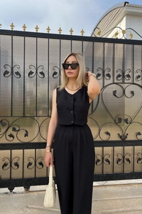 Detail of a chic two-piece summer set with a black vest and high-waist wide-leg pants