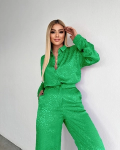 Détail d'un ensemble chemise et pantalon en satin vert émeraude à texture léopard