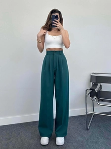 Front view of dark green high-waisted wide-leg trousers with elegant pleated detail