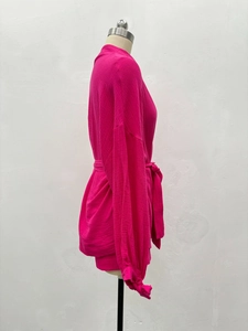 Détail de l'ensemble décontracté rose rouge montrant le tissu gaufré et le lien à nouer