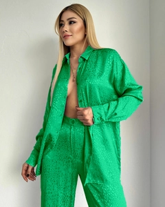 Détail d'un ensemble chemise et pantalon en satin vert vif avec motifs jacquard animal