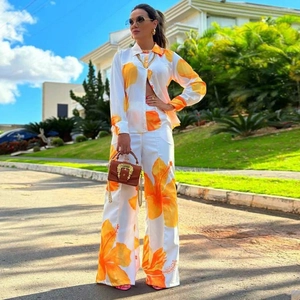 Women's two-piece set featuring long sleeve shirt and wide-leg trousers with orange floral print