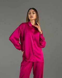 Detailed view of silky rose red satin fabric texture on a long sleeve shirt set