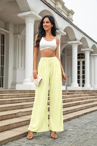 Detail of light yellow plissé wide-leg trousers featuring elegant pleated texture and high waist