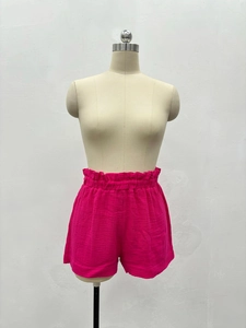 Détail du short taille haute rose rouge avec taille élastique froncée et tissu texturé