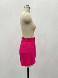 Détail du short rose à taille élastique à volants et tissu avec texture froissée