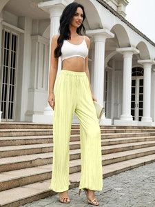 Detail of light yellow pleated wide leg pants with elastic drawstring waist and vertical texture