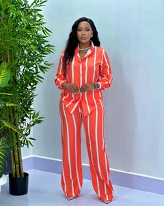 Dettaglio completo di set donna con camicia e pantaloni a righe verticali arancioni e bianchi