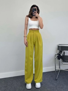 Close-up of high-waisted mustard green wide leg trousers with premium pleated fabric detail