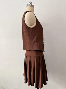 Side view of dark brown sleeveless waistcoat and pleated mini skirt set on mannequin