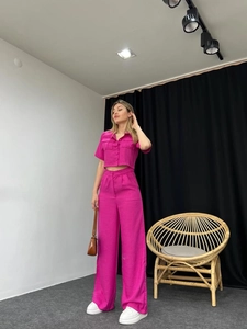 Close-up of women's short sleeve buttoned shirt and wide-leg pants in fuchsia linen texture