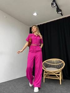 Detail of vibrant rose pink short-sleeve shirt and matching high-waist wide-leg pants set