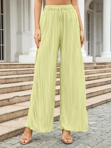 Macro detail of high-waist pleated wide-leg trousers with drawstring in pistachio green