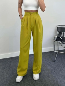 Detail of high-waisted wide-leg trousers in lemon yellow with pleats and side pockets