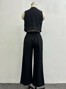 Detail of black sleeveless vest and high waist wide leg trousers on a mannequin
