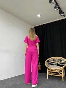 Rear view of fuchsia two-piece set featuring short sleeve top and wide-leg trousers