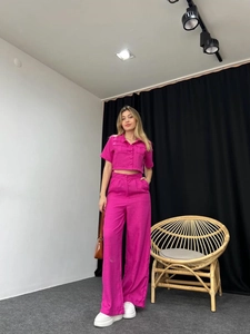 Detailed texture of vibrant pink short-sleeve crop shirt and high-waist wide-leg pants set