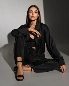 Detailed view of elegant black satin long sleeve shirt and matching wide leg trousers set