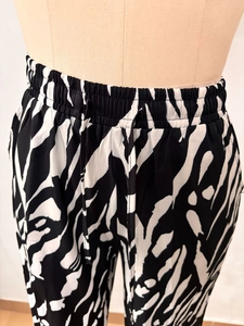 Détail du pantalon taille haute avec imprimé abstrait noir et blanc et cordon de serrage