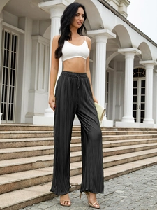 Detail of high waisted black pleated wide leg trousers with adjustable drawstring waist