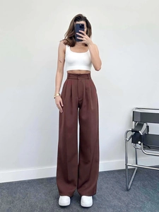 Detail of high-waisted brown wide-leg trousers with front pleats and button closure