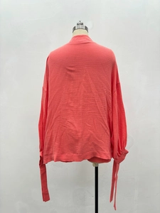 Détail du dos de la chemise rose corail texturée avec poignets à nouer et coupe ample