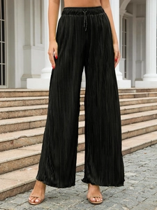 Outdoor view of women's black pleated wide-leg trousers with elastic drawstring waist