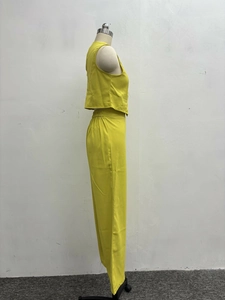Detail of lime green two-piece set featuring cropped vest and high-waist trousers
