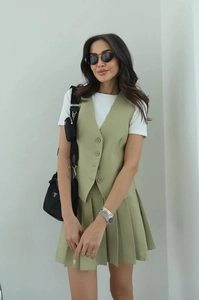 Detail of sage green sleeveless vest and matching high-waisted pleated mini skirt set