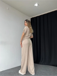 Detail view of beige short sleeve top and wide leg linen pants with natural texture