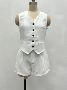 Détail de l'ensemble gilet blanc sans manches col V avec cinq boutons noirs et short assorti