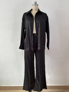 Détail de la chemise et du pantalon en satin noir avec texture léopard subtile