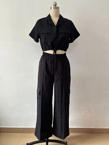 Vue de face de l'ensemble cargo noir deux pièces avec crop top manches courtes et pantalon