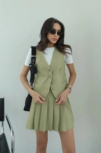Detailed view of olive green sleeveless vest and pleated skirt set for women
