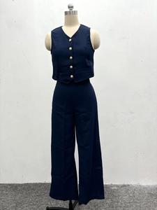 Detail of dark blue two-piece set featuring V-neck vest with gold buttons and wide-leg pants