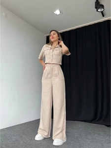 Close-up of beige linen two-piece set with short sleeve shirt and wide leg pants