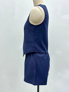 Détail d'un ensemble bleu marine avec gilet sans manches et short assorti sur un mannequin