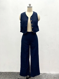 Detail of dark blue vest and wide-leg trousers set with embossed gold buttons