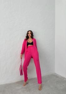 Detail of hot pink three-piece set with ribbed cardigan and high-waisted trousers