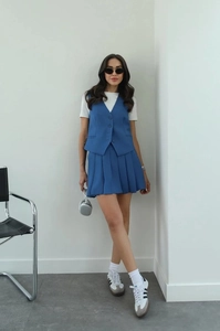 Detailed close-up of blue sleeveless V-neck vest and matching pleated mini skirt set