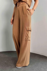 Détail du pantalon cargo beige avec taille élastique large et grandes poches latérales