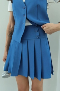 Detail of royal blue sleeveless vest and high-waisted pleated skirt two-piece set