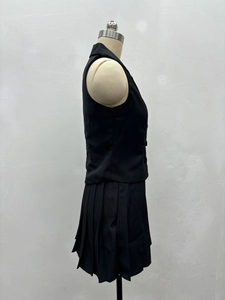 Vue détaillée du gilet noir sans manches à revers et de la jupe plissée assortie pour femme